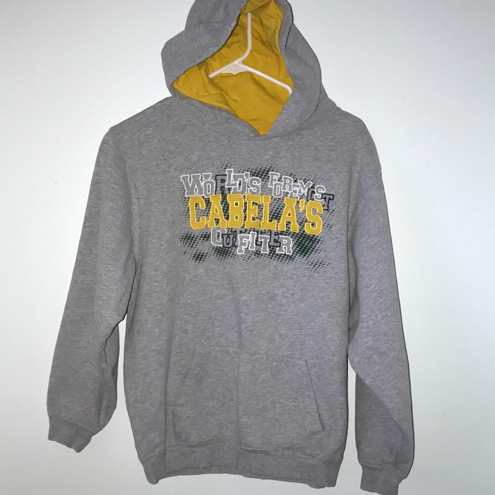 Cabelas hooded sweatshirt says “Worlds Formost Cabela’s Outfitter size XL